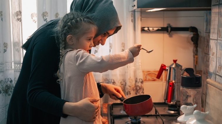 Ibu dan anak menyiapkan kebutuhan bersama di dapur